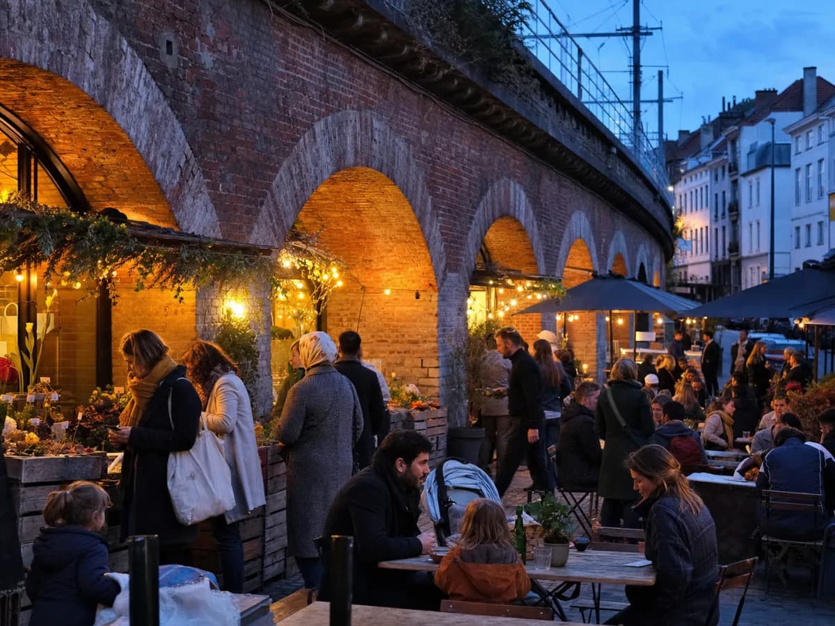 People visiting an evening market beneath brick railway arches